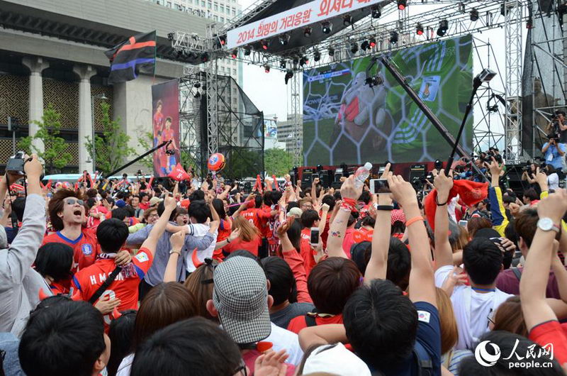 브라질 월드컵 H조 예선 한국과 러시아 경기에서 골이 터지자 광화문광장에 모인 사람들이 기뻐하고 있다.