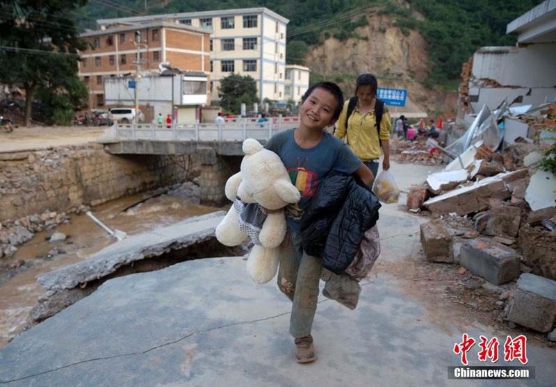 11살 뤄톈지(羅天吉) 어린이는 폐허 속에서 장난감을 찾아내어 들고선 재해대피소로 향하고 있다. 중국신문사 런동(任東) 촬영기자