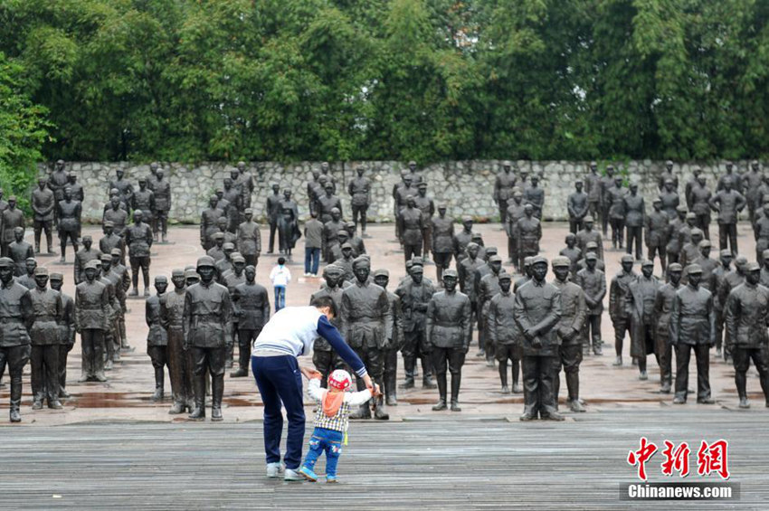 항일전쟁 노병 자오부윈（趙步雲） 씨의 손자와 증손자가 열사조각광장으로 걸어가고 있다.