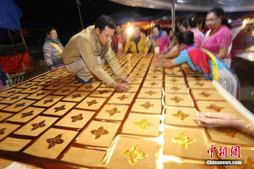 마을 사람들이 금색 가사(袈裟)에 금박을 붙이는 모습