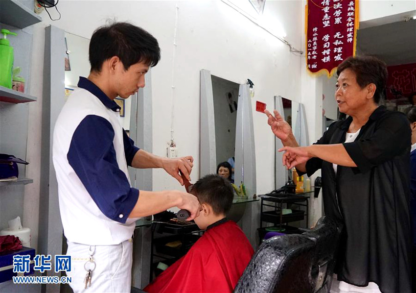 천쥐롄(陳菊連, 오른쪽) 씨가 미용실에서 수습생에게 커트 기술을 지도하고 있다.