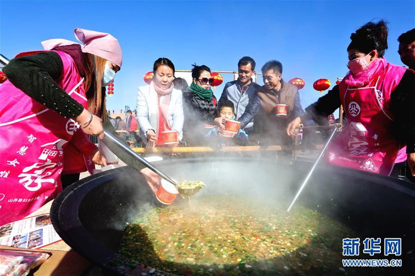 12월 21일 간쑤(甘肅)성 장예(張掖)시 산단(山丹)현 칭취안(淸泉)진 치뎬(祁店)촌, 사람들이 뜨거운 ‘뉴와쯔판(牛娃子飯)’을 받아 가는 모습