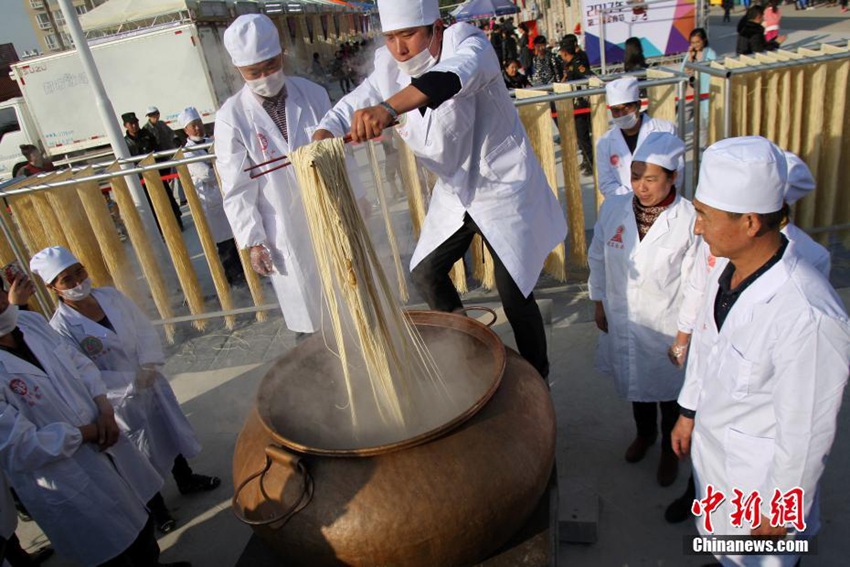 요리사들이 직경 1.8m, 무게 180kg에 달하는 솥에 면을 끓이는 모습