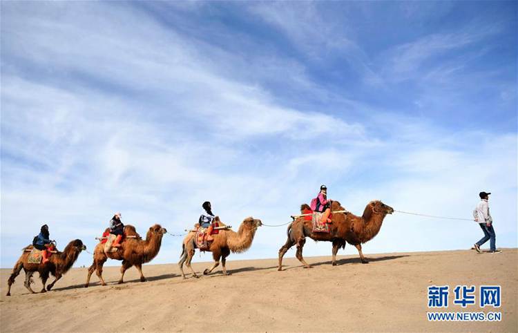 5월 3일, 여행객이 둔황(敦煌, 돈황) 밍사산(鳴沙山, 명사산)에서 낙타를 타고 있다.