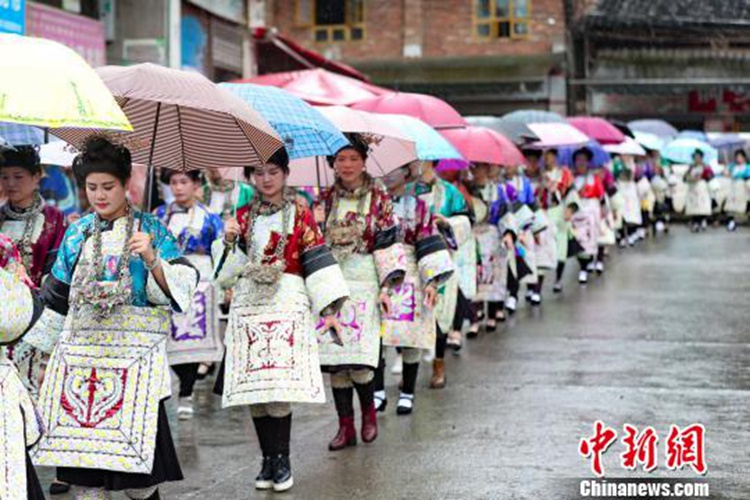 구이저우(貴州, 귀주)성 룽장(榕江)현에 사는 젊은 동족(侗族) 여성들이 가랑비를 맞으며 자신이 입은 의상을 선보이고 있다.