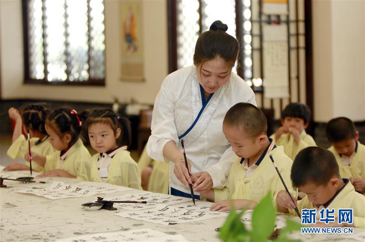 어린이들이 국학관(國學館) 선생님에게 서예를 배우는 모습