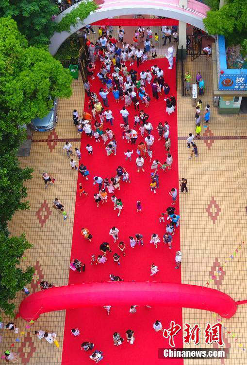 8월 31일, 장시(江西) 주장(九江)초등학교에서 학부모들이 1학년 아이들과 레드카펫을 밟고 학교 안으로 들어가고 있다. 