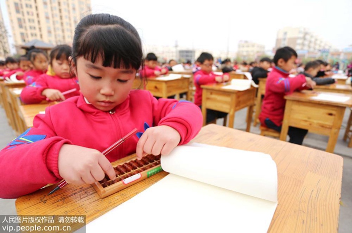 11월 21일 장쑤(江蘇, 강소)성 둥하이(東海)현 실험초등학교 1학년 학생들이 운동장에서 주판속셈 수업을 하는 모습이다.