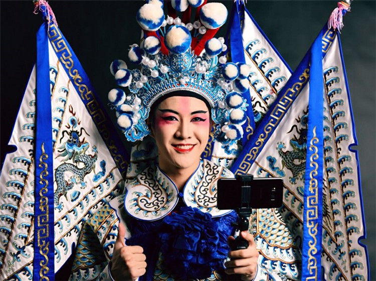 싸이원치(賽文柒)가 춘제(春節, 춘절: 중국의 설) 기간 전통 경극 의상을 입고 인터넷 방송을 하고 있다.