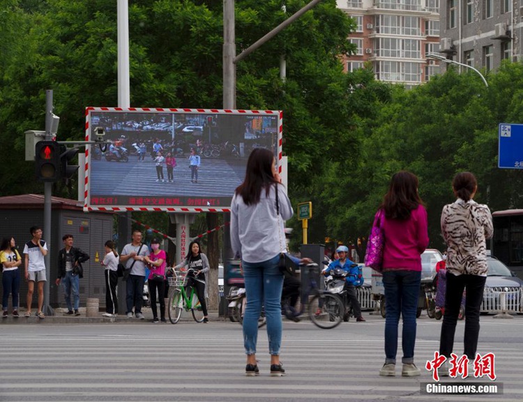 베이징 도로에 신호 위반하는 행인 보여주는 대형 스크린 설치