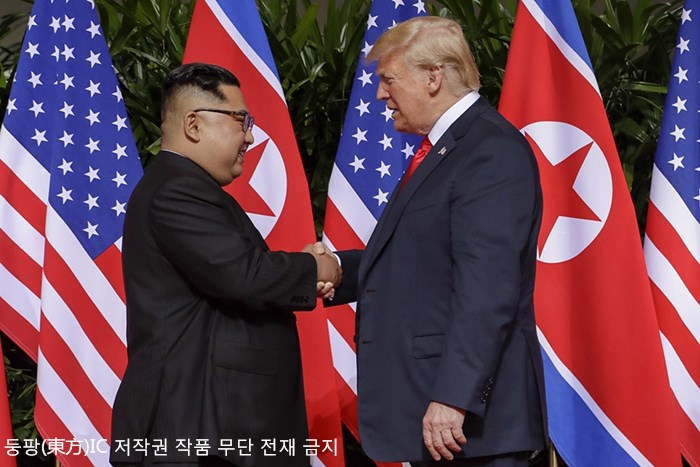 첫 조미 정상회담, 김정은과 트럼프의 역사적인 악수 장면