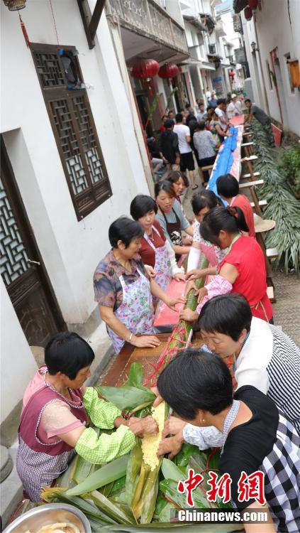 현지 주민들이 ‘용 쭝쯔(粽子: 찹쌀을 갈대 잎이나 대나무 잎에 싸서 찐 음식)’를 만들고 있다. [사진: 쑤이창(遂昌)현 정부 선전부처 제공]