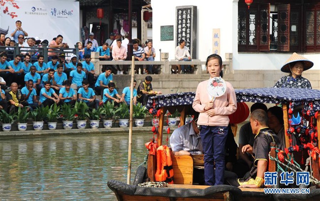 지난 7일 대회 참가자가 요로선(搖櫓船) 위에서 시를 낭독하고 있다.[사진 출처: 신화사/촬영: 주구이건(朱桂根)]