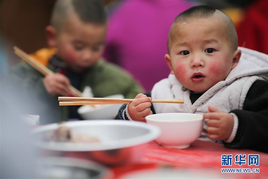 지난 31일 구이저우(貴州)성 이디푸핀(易地扶貧) 단지, 어린이들이 퇀위안판(團圓飯)을 먹고 있다. [사진 출처: 신화사/촬영: 장후이(張暉)]