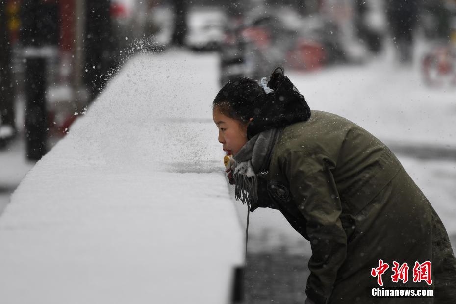 2월 12일 한 여성이 눈을 불어 날리고 있다. [촬영: 중국신문사 추이난(崔楠) 기자]