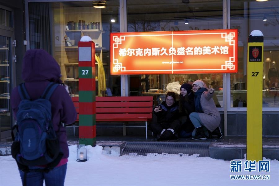 지난 13일 노르웨이 동북부 항구도시 키르케네스를 찾은 관광객들이 중국어로 된 간판 앞에서 기념촬영을 하고 있다. [촬영: 신화사 량유창(梁有昶) 기자]