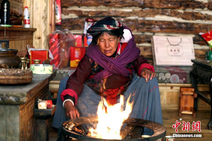 3월 11일, 리유좌(李友抓) 할머니가 조모옥(祖母屋)에서 화롯불을 피우고 있다. [촬영: 중국신문사 왕레이(王磊) 기자]