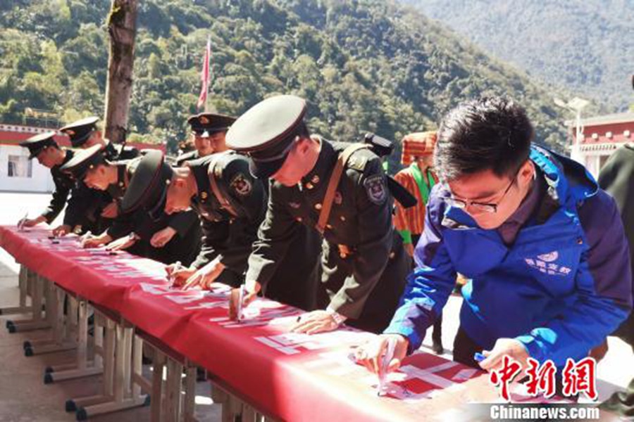 사진은 군민(軍民)들이 ‘위마이(玉麥)지역의 수호정신을 배우고 공헌을 가르치고, 국경을 지키고, 신성한 국토 수호자가 되고, 행복한 가정을 만드는 사람이 되자’라고 적힌 플래카드에 서명을 하는 모습이다. [사진 출처: 중국신문망/촬영: 마쥔(馬軍)]