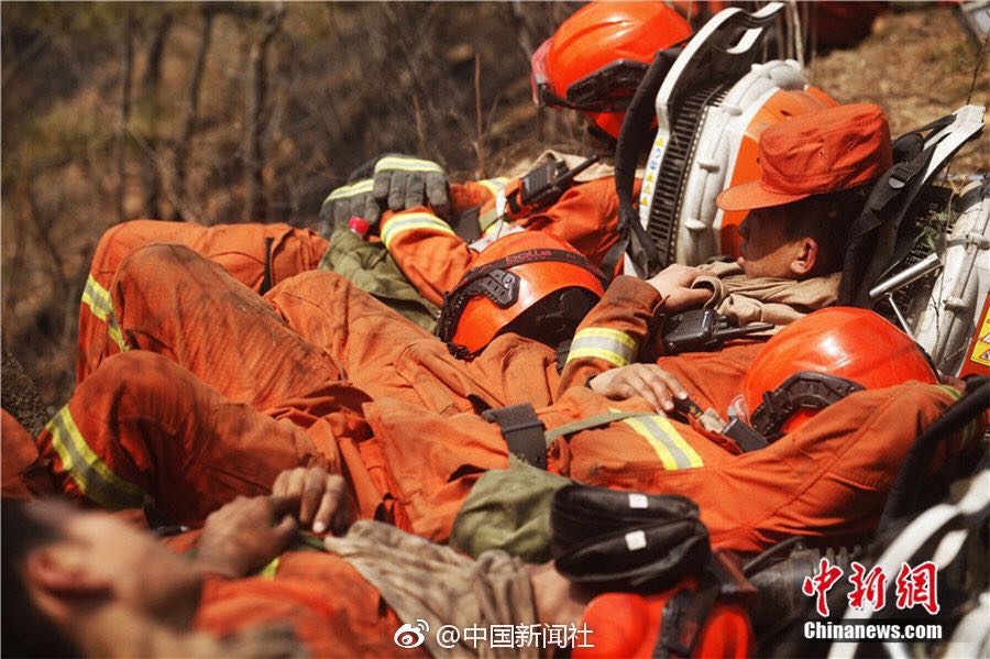 피로가 극에 달한 소방대원들은 화재진압 장비를 짊어진 채 땅바닥에 누워 잠을 잔다. [사진 출처: 중국신문사, 산시망, 감쑤삼림소방]