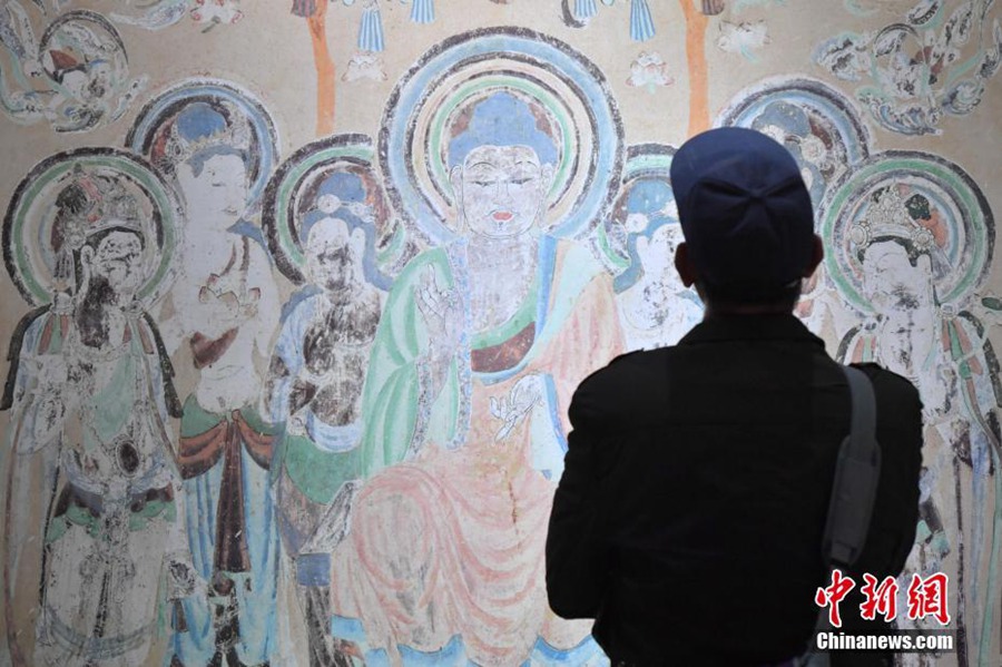 4월 11일, 한 관람객이 둔황(敦煌) 벽화를 관람하고 있다. [촬영/중국신문사 런둥(任東) 기자]