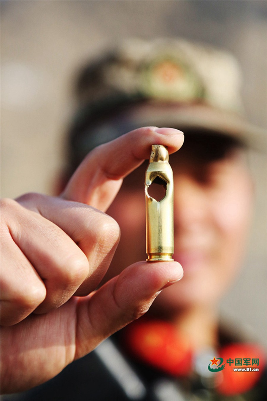 한 특전대원이 총알이 관통한 탄피를 보여주고 있다.