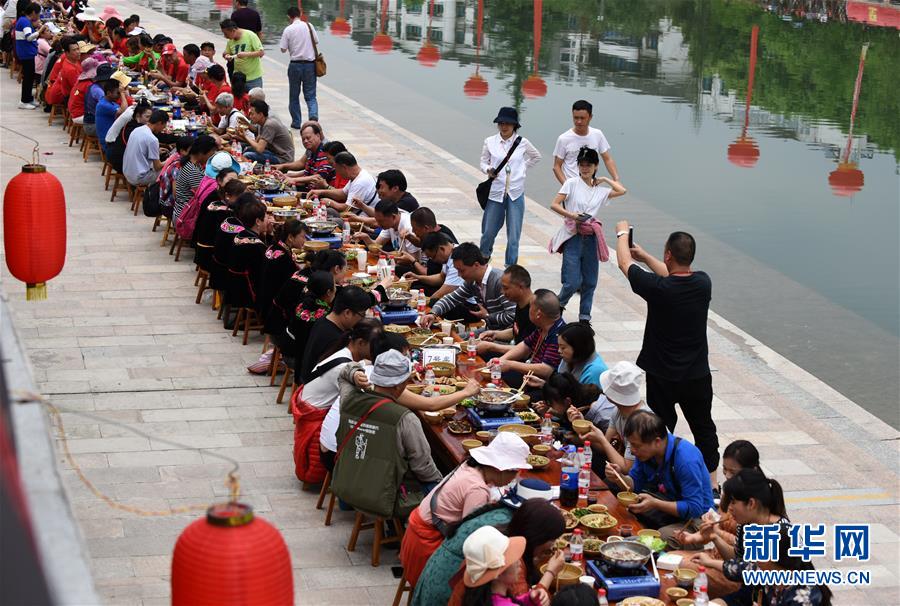 지난 18일 관광객들이 타이장현에서 개최한 묘족 쯔메이제 천인 테이블 행사를 체험하고 있다. [촬영: 신화사 양원빈(楊文斌) 기자]