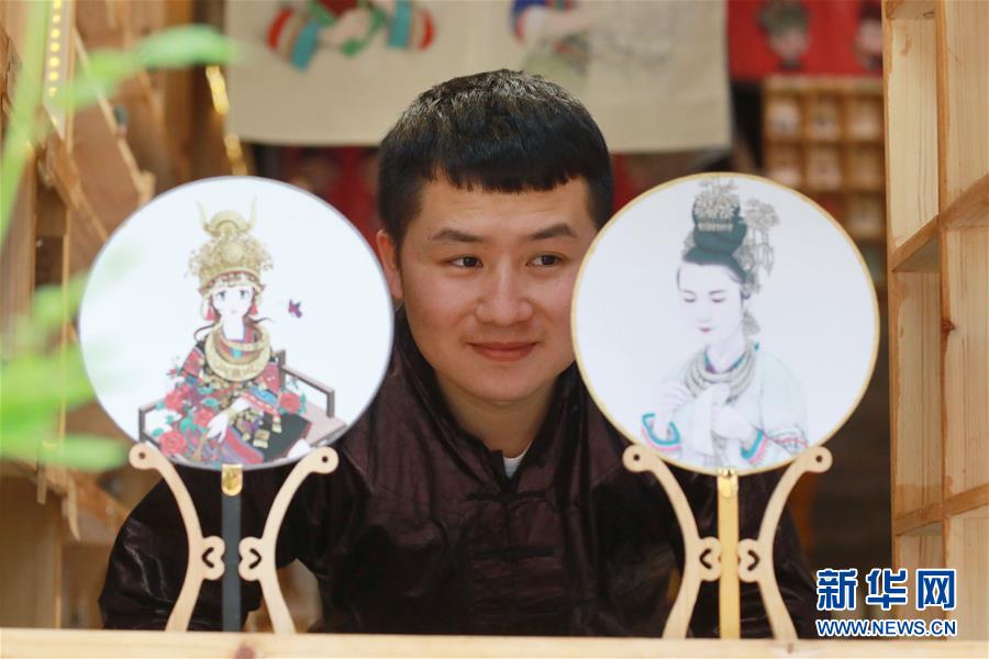 4월 16일, 란차이성(蘭才生) 씨가 삽화관에서 자신이 직접 만든 부채 작품을 살펴보고 있다. [촬영: 신화사 어우둥취(歐東衢) 기자]