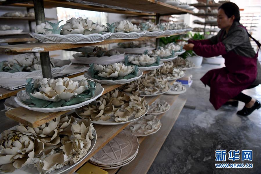 뤄양(洛陽)모란자기주식회사의 직원이 반제품을 탁자 위에 진열하고 있다. [4월 25일 촬영: 신화사 리자난(李嘉南) 기자]