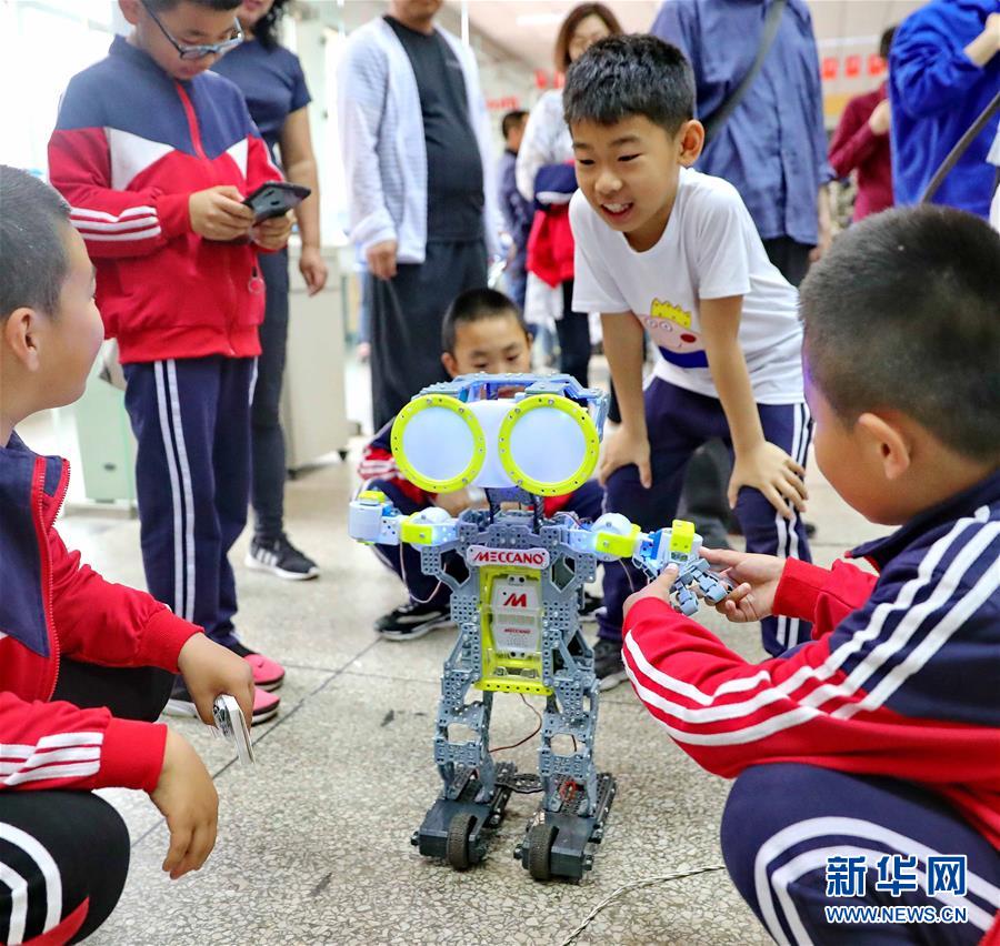 한 어린이가 허베이(河北)성 친황다오(秦皇島)시 옌산(燕山)대학 로봇과 호흡을 맞추는 모습이다. [사진 출처=신화사]