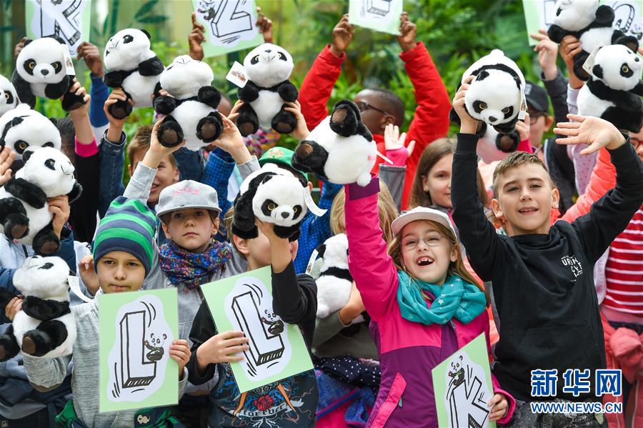 5월 20일 오스트리아 비엔나 쇤브룬 동물원을 찾은 어린이들이 판다 인형을 들고 흔들며 ‘위안위안(園園)’을 환영하고 있다. [촬영: 신화사 궈천(郭晨) 기자]