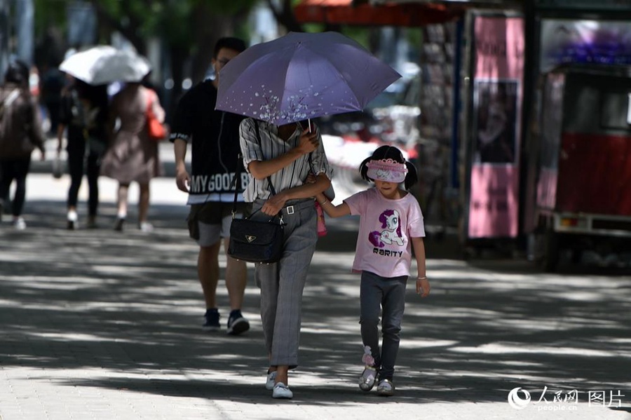 5월 22일 베이징에 폭염주의보가 발령됐다. 대다수 시민들은 양산, 모자, 선글라스로 무장하고 외출을 했다.