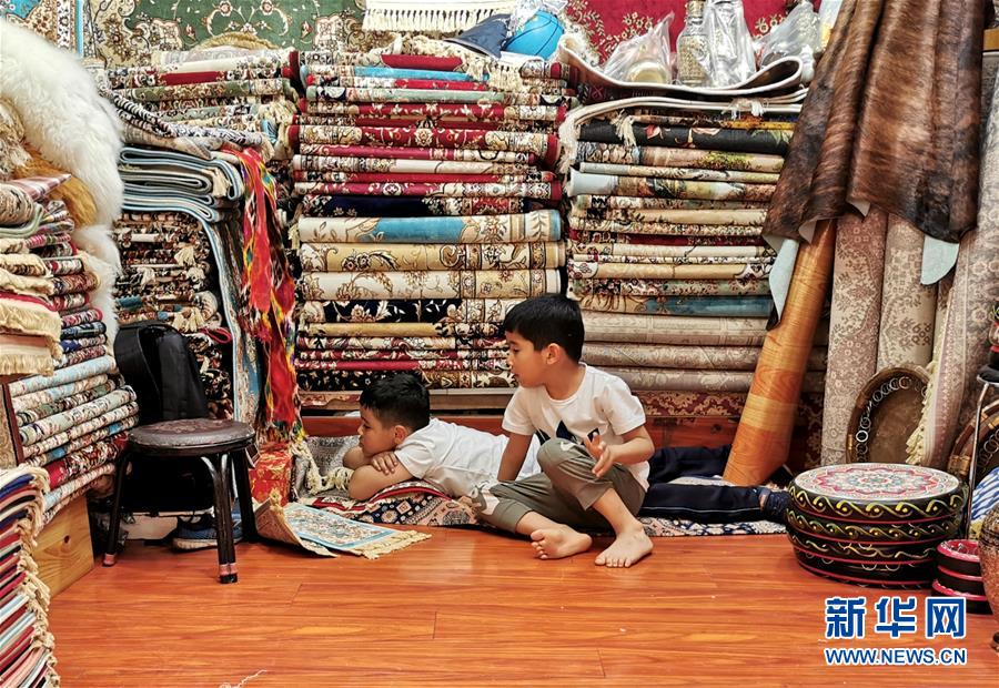 우루무치(烏魯木齊) 국제 그랜드 바자르의 한 카펫트 상점에서 장난 치는 아이들  [사진 출처=신화사]