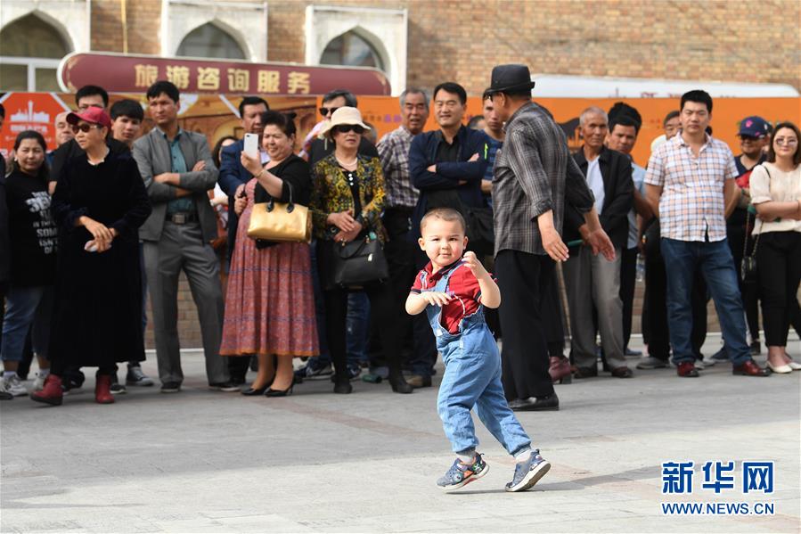 우루무치(烏魯木齊) 국제 그랜드 바자르에서 흘러나온 음악에 춤추는 아이 [사진 출처=신화사]