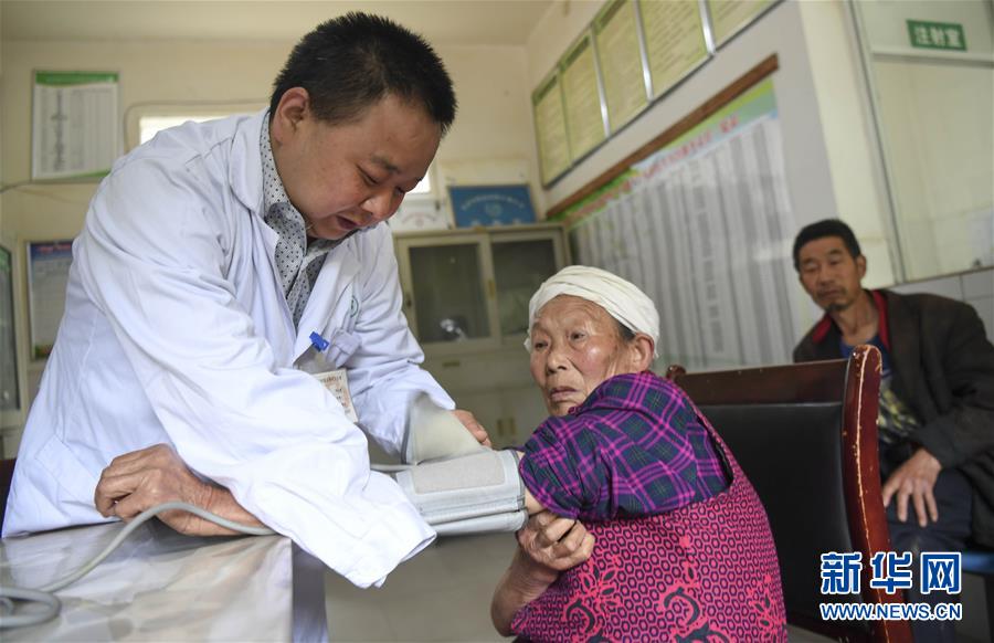 허융칭(何永淸∙왼쪽)이 마을 보건소에서 환자와 진료 상담을 하고 있다. [사진 출처: 신화망]