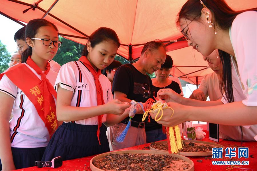 지난 4일 2019푸저우(福州市)시 ‘우리의 명절•단오’ 창산(倉山)구 행사에서 직원들이 어린이들의 향낭 다는 것을 도와주고 있다. [사진 출처: 신화망]