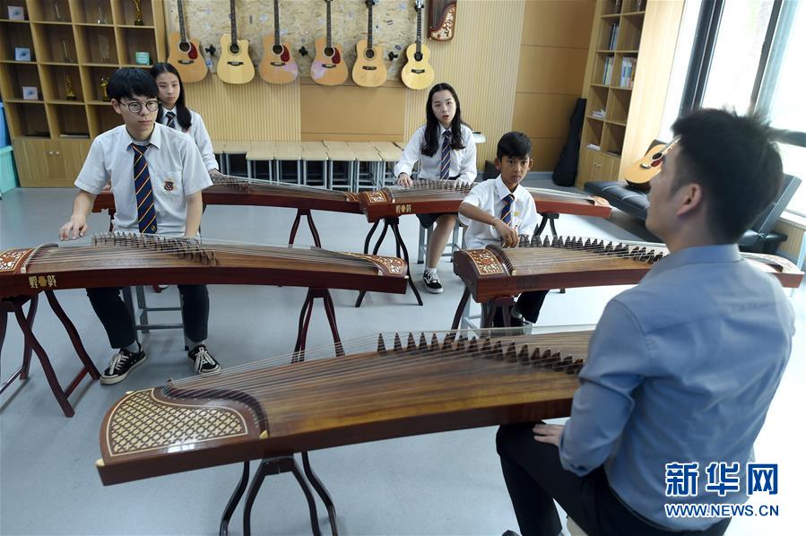 살릭(우2)은 학교에서 중국 전통악기 시간에 고쟁을 배우고 있다. [사진 출처: 신화망]