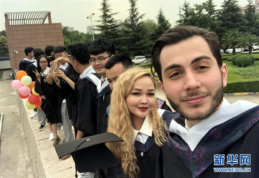 조니(왼쪽 첫 번째)와 학생들이 학사모에 가운을 입고 산시중의약대학교(陜西中醫藥大學) 캠퍼스에서 기념 촬영을 하고 있다. [사진 출처: 신화망]