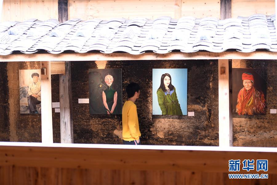 한 관광객이 ‘룽탄(龍潭) 미술관’에서 룽탄촌 사람이 그린 유화 작품을 감상하고 있다. [사진 출처: 신화망]
