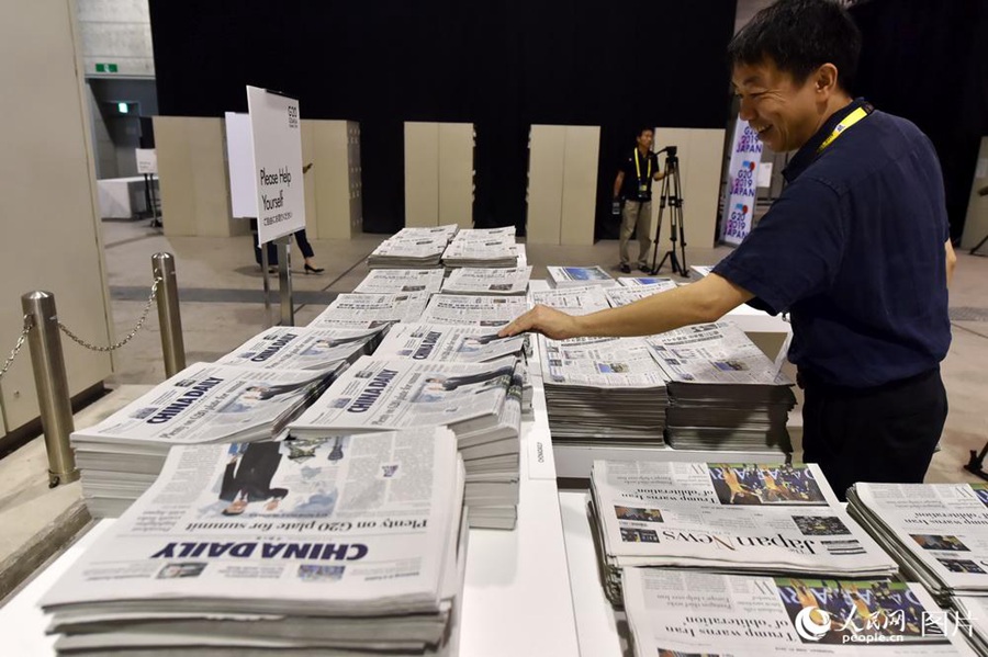 6월 27일 G20 오사카 정상회의 프레스센터에서 기자가 신문을 챙기고 있다. [사진 출처: 인민망]