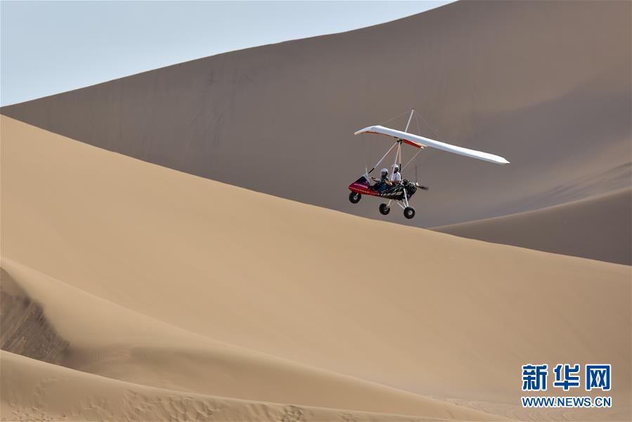 7월 2일 쿠무타거(庫木塔格)사막, 관광객들이 삼각익기를 타고 사막을 구경하고 있다. [사진 출처: 신화망]