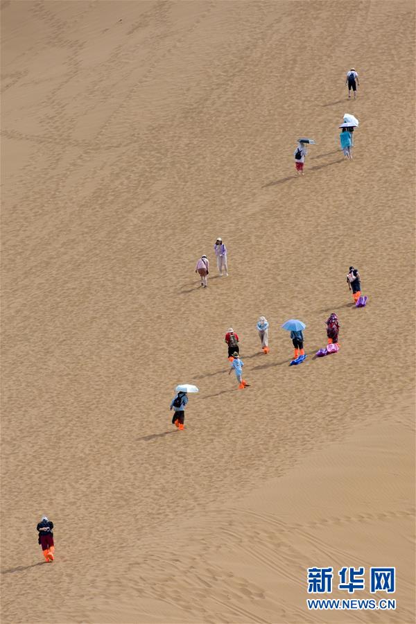 7월 2일 쿠무타거(庫木塔格)사막, 관광객들이 모래언덕을 넘고 있다. [사진 출처: 신화망]
