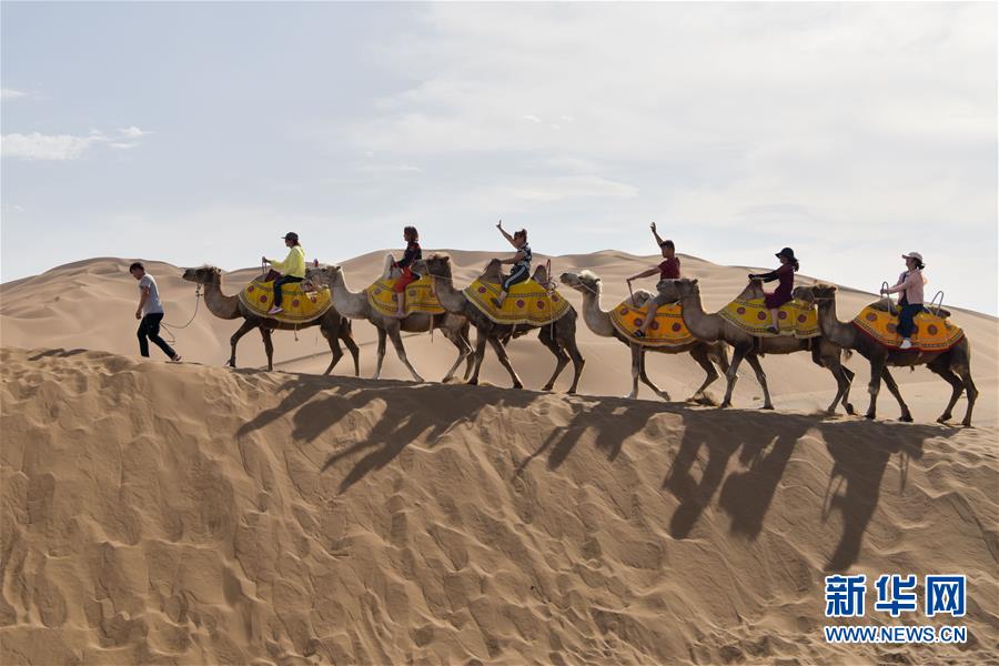 7월 2일 쿠무타거(庫木塔格)사막, 관광객들이 낙타를 타고 있다. [사진 출처: 신화망]