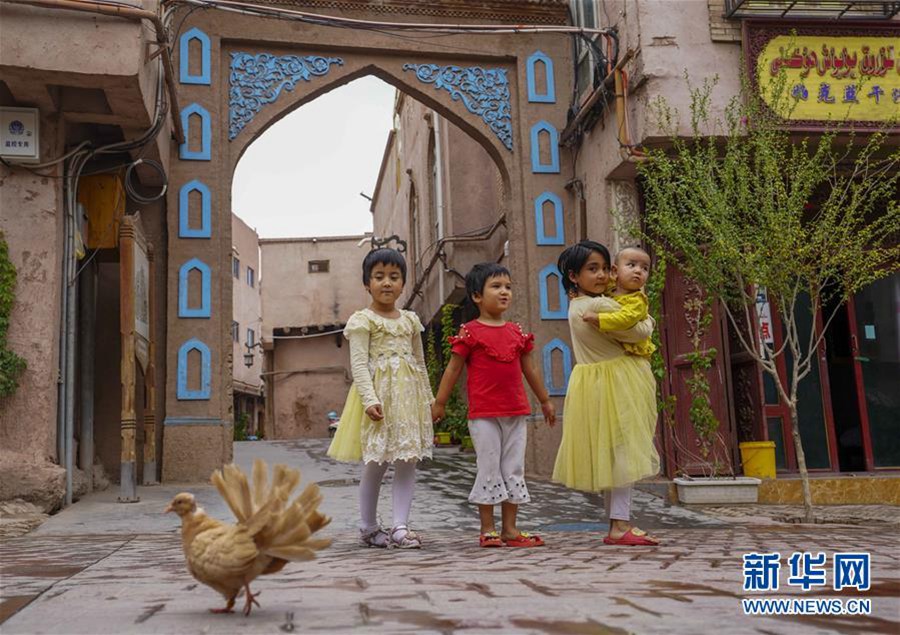 7월 7일, 어린이들이 비를 맞으며 카스(喀什)고성(古城) 관광지를 둘러보고 있다. [사진 출처: 신화망]