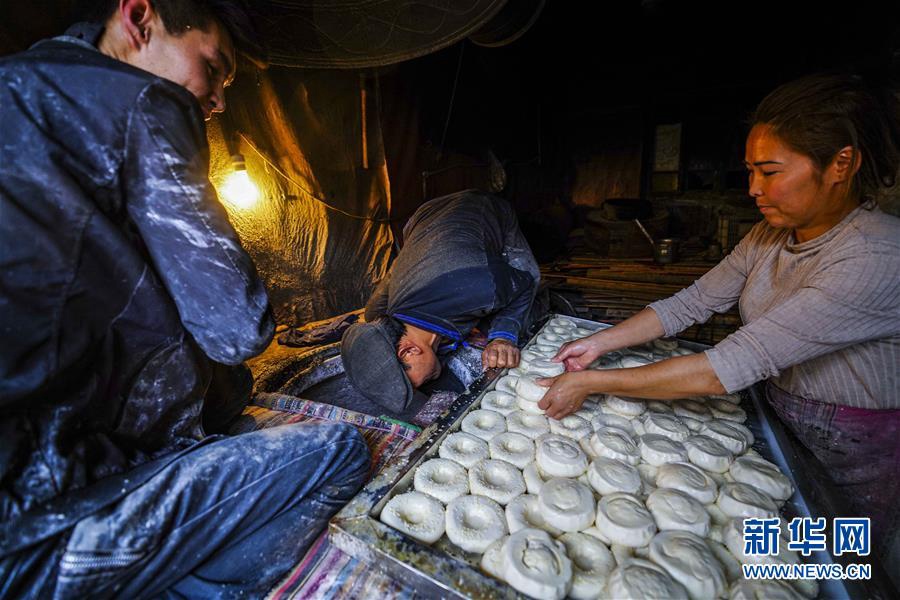 7월 7일 카스(喀什)고성(古城) 관광지, 낭[饢: 위구르족(維吾爾族)과 카자흐족(哈薩克族)이 즐겨먹는 밀가루빵] 가게 주인이 낭을 만들고 있다. [사진 출처: 신화망]