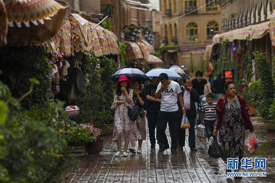 7월 7일, 관광객들이 비를 맞으며 카스(喀什)고성(古城) 관광지를 들러보고 있다. [사진 출처: 신화망]