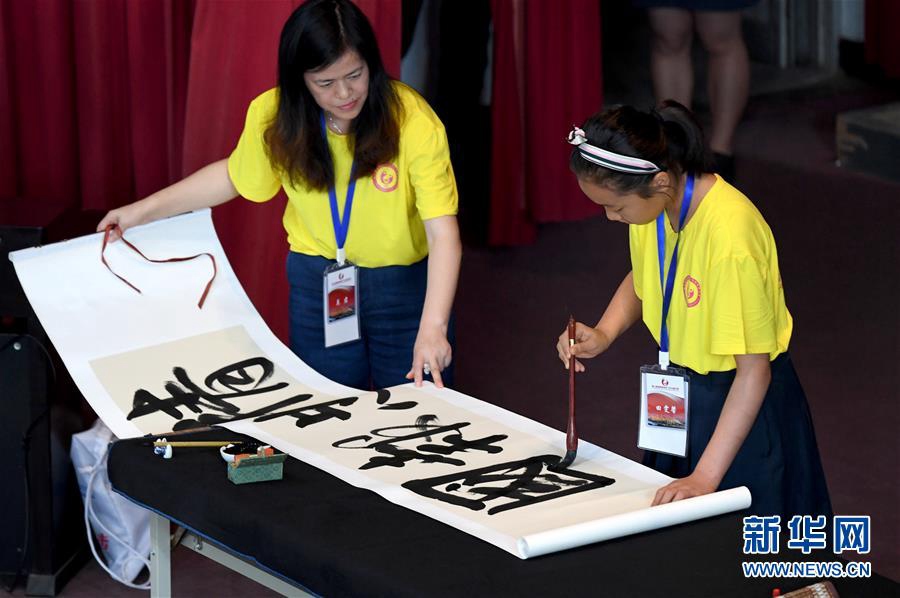 7월 9일, 교류행사에 참가한 한 학생이 개막식에서 서예를 선보이고 있다. [사진 출처: 신화망]