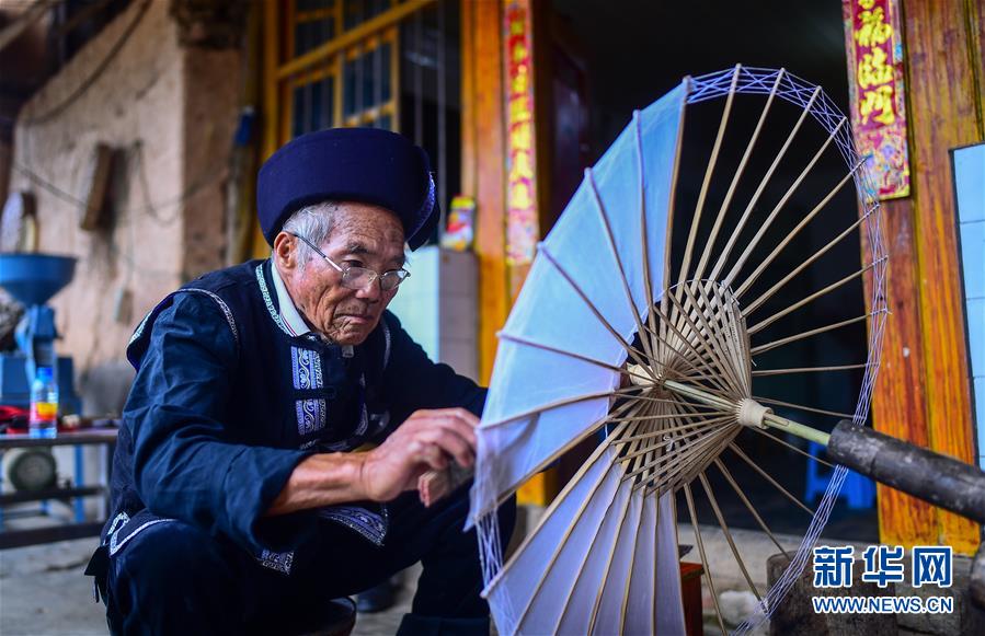장룽화(張榮華) 노인이 마당에서 수죽꽃우산을 제작하고 있다. [사진 출처: 신화망]