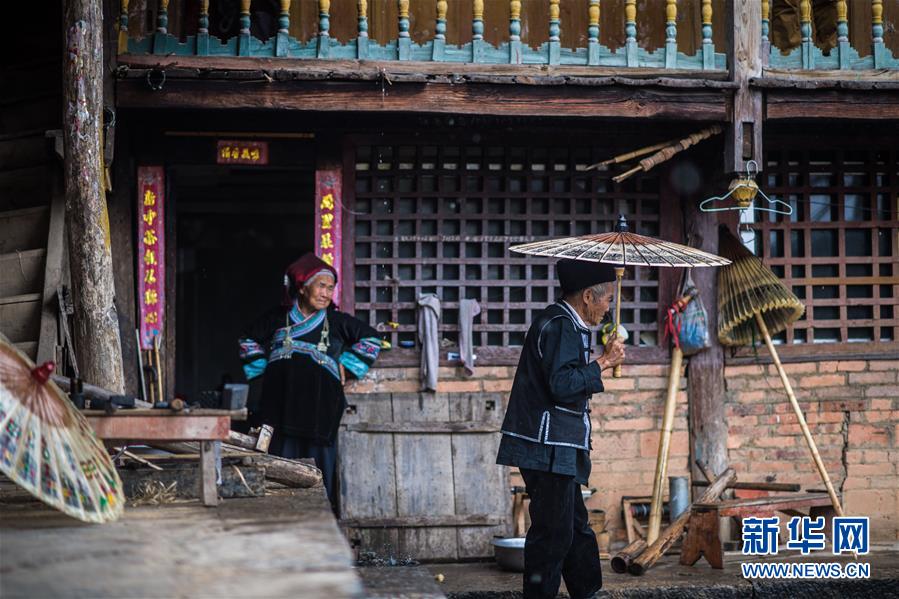 장룽화(張榮華•오른쪽) 노인 완성된 수죽꽃우산을 써보고 있다. [사진 출처: 신화망]