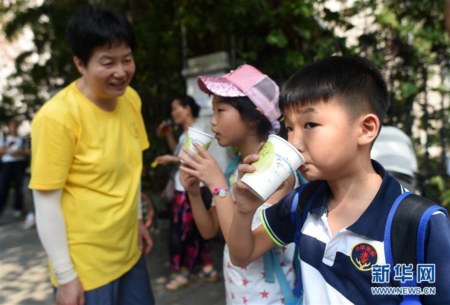 7월 14일, 어린이들이 량차(凉茶) 가판대 앞에서 차를 마시고 있다. [사진 출처: 신화망]