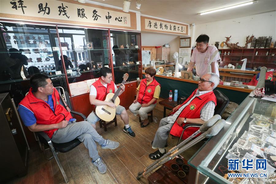 7월 11일 츠샹(慈祥, 왼쪽2번째) 씨가 학생들을 위해 기타 연주를 하고 있다. [사진 출처: 신화망]
